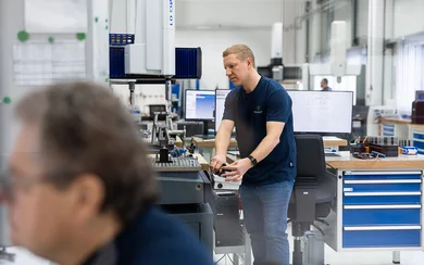 Ein Mitarbeiter der Qualitätssicherung bedient eine Messmaschine